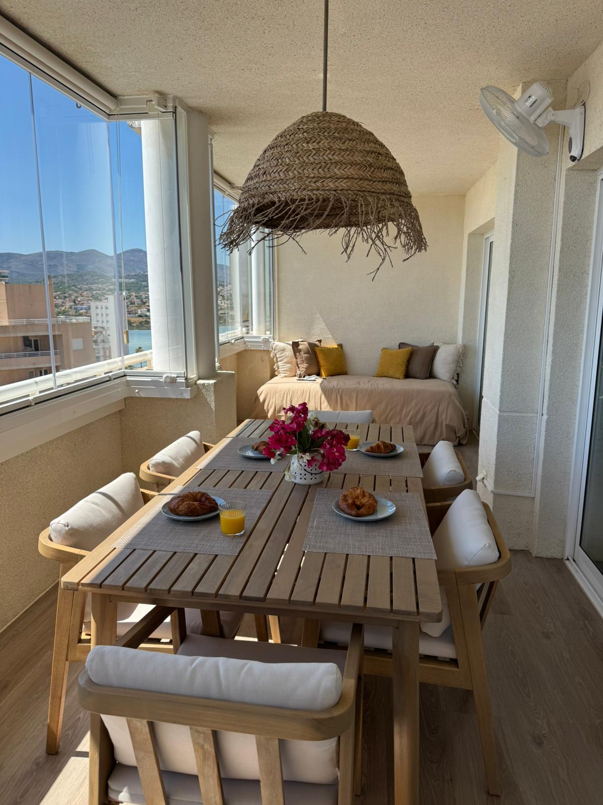 Loggia dining area with hanging chairs and mountain view