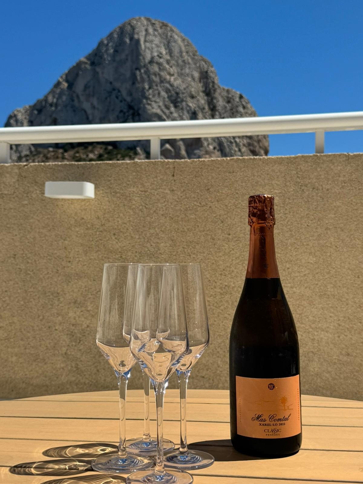 Sparkling wine and glasses on the terrace table with the Ifach rock behind